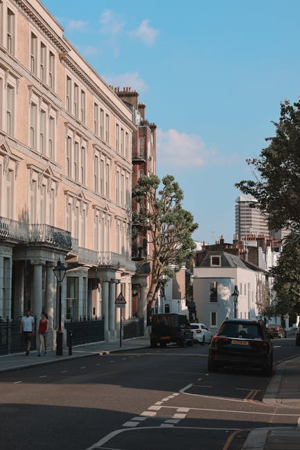 Two movers from Self Storage Islington are standing inside a residential hallway near a door with a black frame, preparing for house relocation or furniture transport as part of a packing and moving p